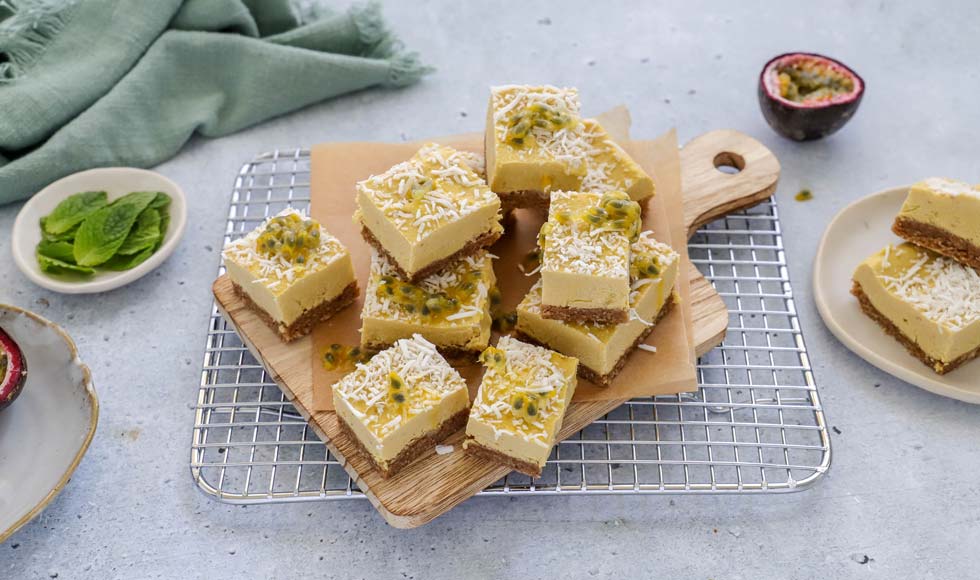 Pine and mango plant-based bars served on a chopping board with fresh passionfruit