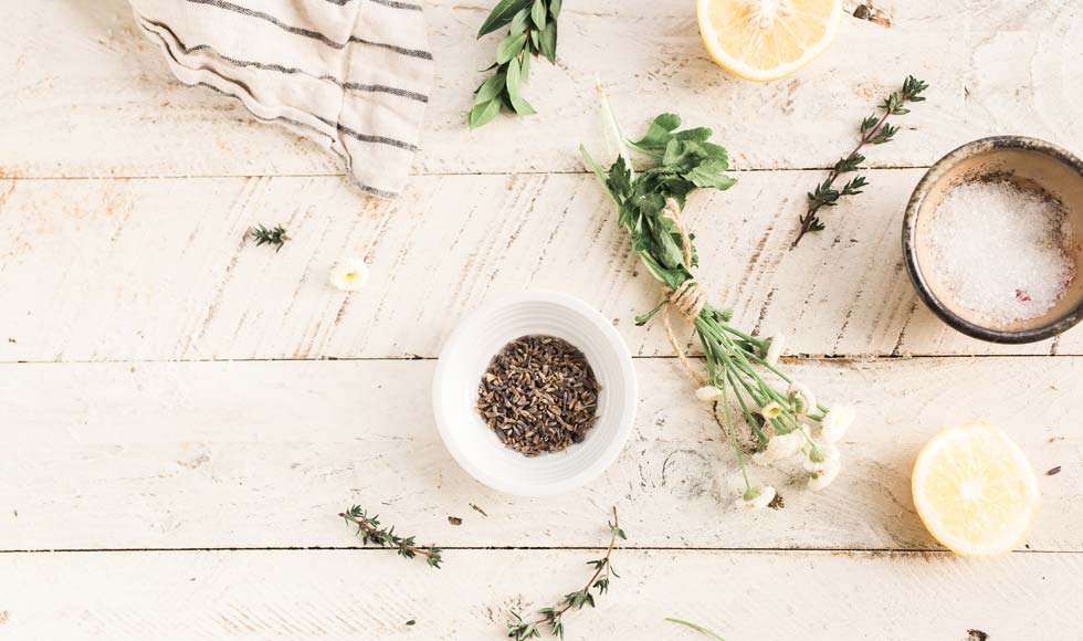Lavender, lemon, salt and green vegetables on a white timber background